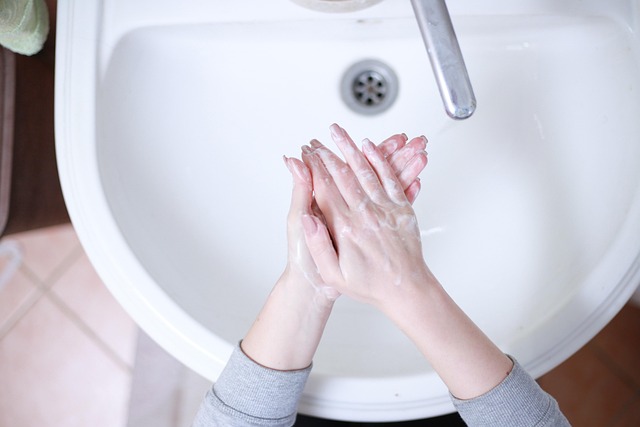 Hand washing in a restaurant kitchen sink with soap and sanitizer